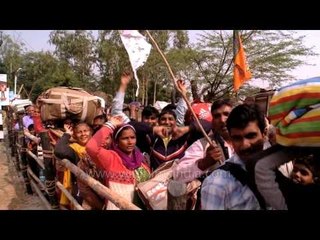 Pilgrims of Gangasagar mela waves at the camera