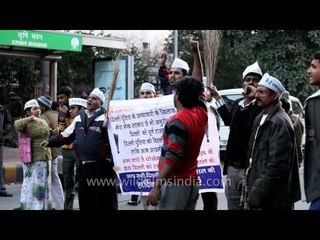 AAP supporters in white cap, waving broom in New Delhi