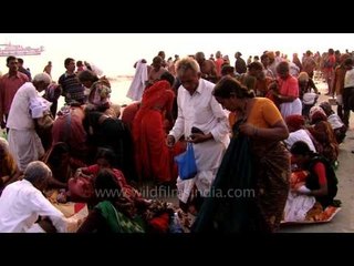 Indian pilgrims putting their clothes on after a holy dip