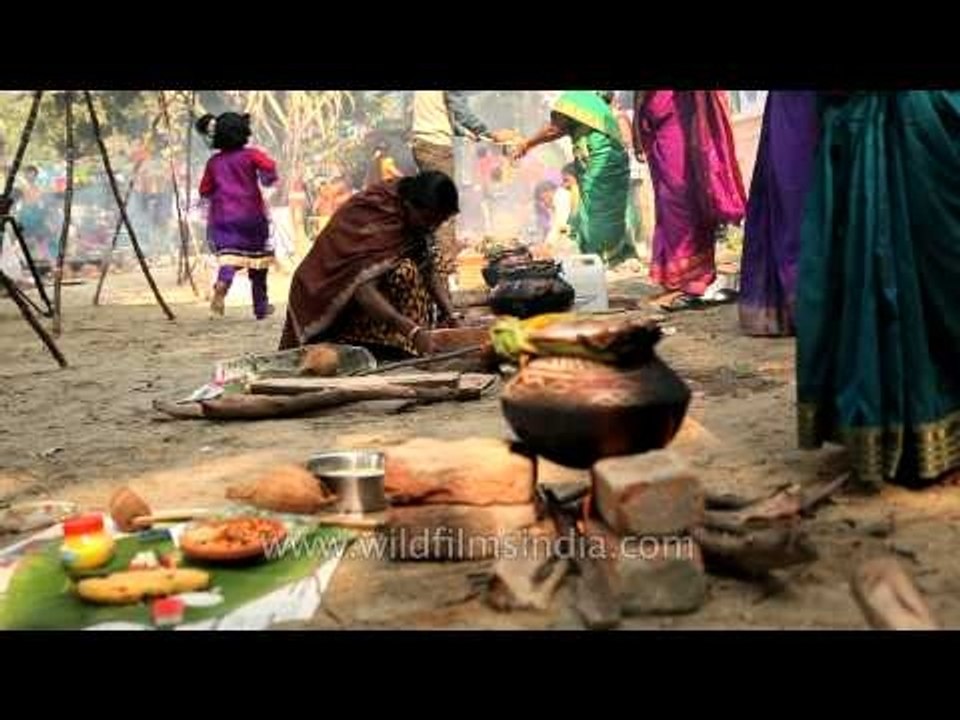 Lady pushes firewood to keep fire burning