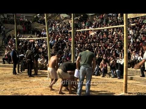 Naga participants getting ready to kick the piece of meat hanging on the bamboo