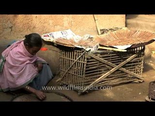 Young boy stares on as his mother seives pulses