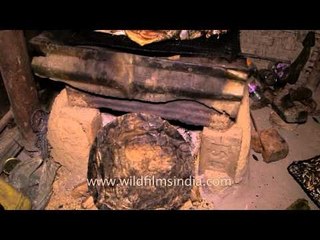 Fish being placed on the tray to be smoked on fire in Manipur
