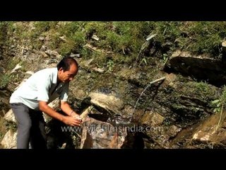 Man quenching thirst with mountain spring water, Mizoram