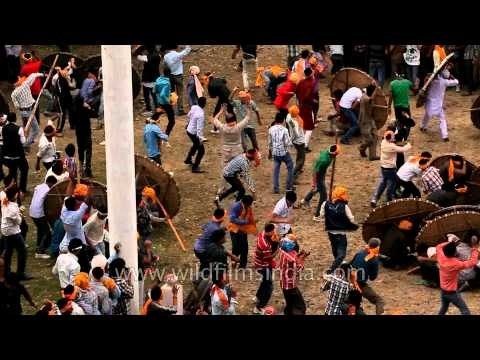 People fighting a battle in front of the temple, throwing stones at each other