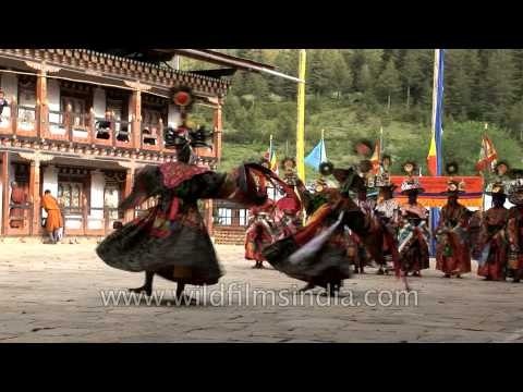 Monks wearing large black hats performs the Shana Cham dance in Bhutan