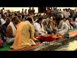 Devotees and priest perform puja during Maha Kumbh Mela in Allahabad