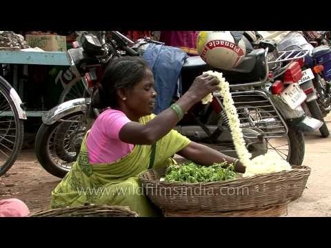 Woman selling flower garlands on street in India