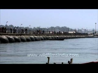 Hindu devotees cross pontoon bridges spanning the river Ganges during Maha Kumbh