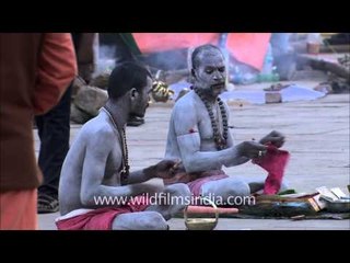 Hindu holy man sits with others during an evening prayer at Varanasi