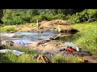 Villager women wash laundry in river, Kerala
