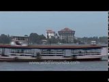 Large ships and boats pass by large buildings in Kochi