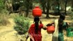 Women balancing pots of water from a well in Manegaon village