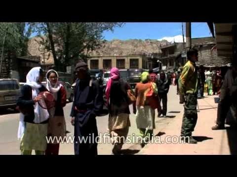 Prayer flags on sale and girl students laugh at Ladakh market