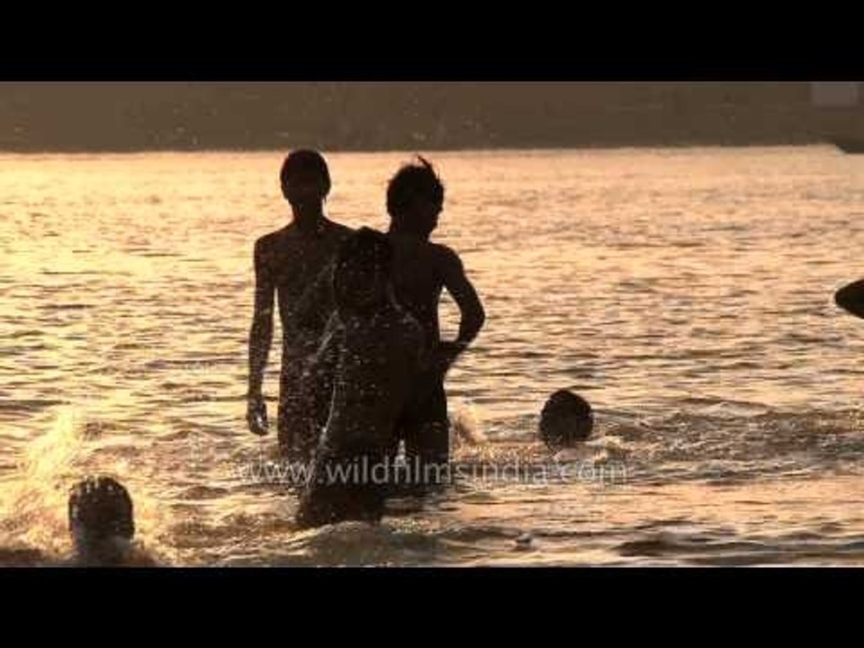 Boys having fun splashing around in the river Ganges, Varanasi