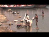 Heavily polluting Ganges river: Washing clothes and bathing in Varanasi