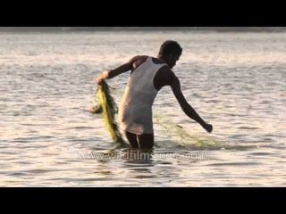 Fishermen busy spreading fishing net in Ganga river, Varanasi