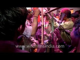 Man with his little son performing the procession of Lath mar Holi