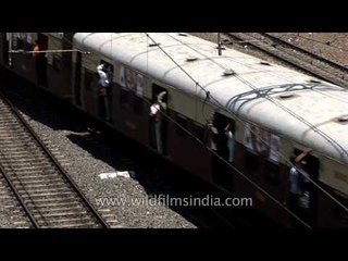Trains arrive and leave at a busy station in Mumbai