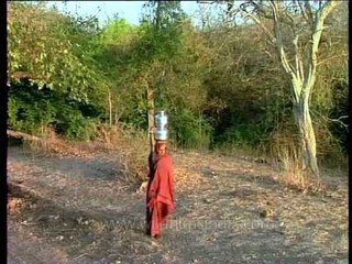 Maldhari woman with two water pitchers balanced on her head under the scorching heat!