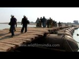 Tourista crossing a makeshift pontoon bridge over the Chambal river