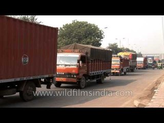 Langur wallah ferries his simian while trucks drive to Delhi Airport