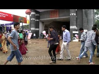 Women hitch up sarees to cross muddy wet ground