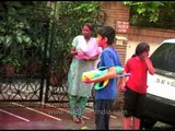 Splashing bucketfuls of colored liquids on loved ones during Holi