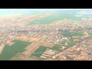 Green fields with buildings aerial view in Aonla