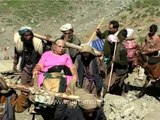 Porters carry an aged woman pilgrim en route Amarnath Yatra