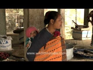 A Manipuri woman carrying a baby at her back at Senapati District