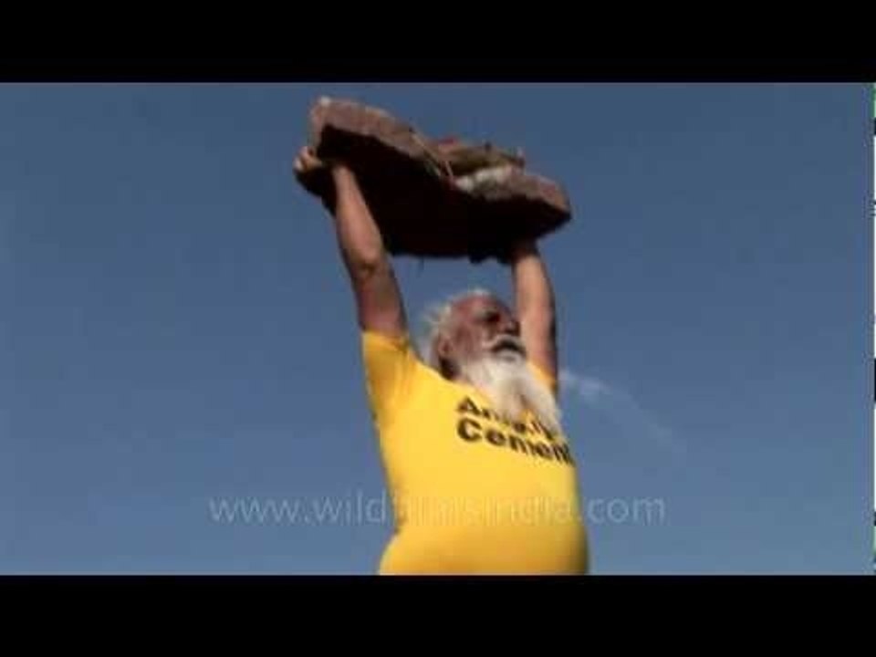 Old man lifting heavy stone with bare hands