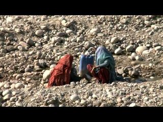 Tribal Gujjar women filtering stream water for drinking in Rajaji National park