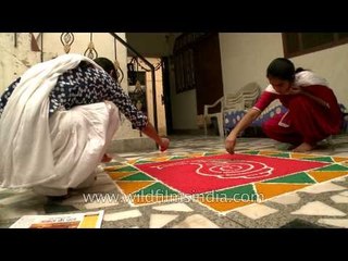 Girls preparing colorful rangoli for Diwali