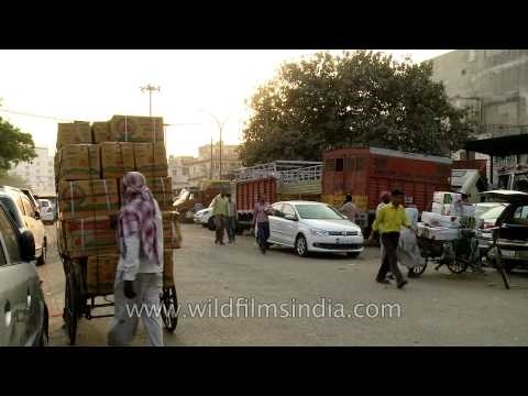 Fruits and veggies stacked up on tri-cycle goods carriers in the Azadpur mandi