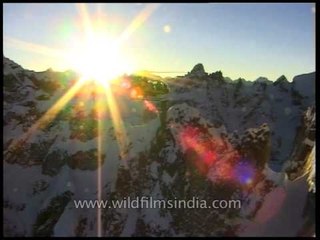 Sun's golden rays sparkling like cosmic glitter in the Himalayas