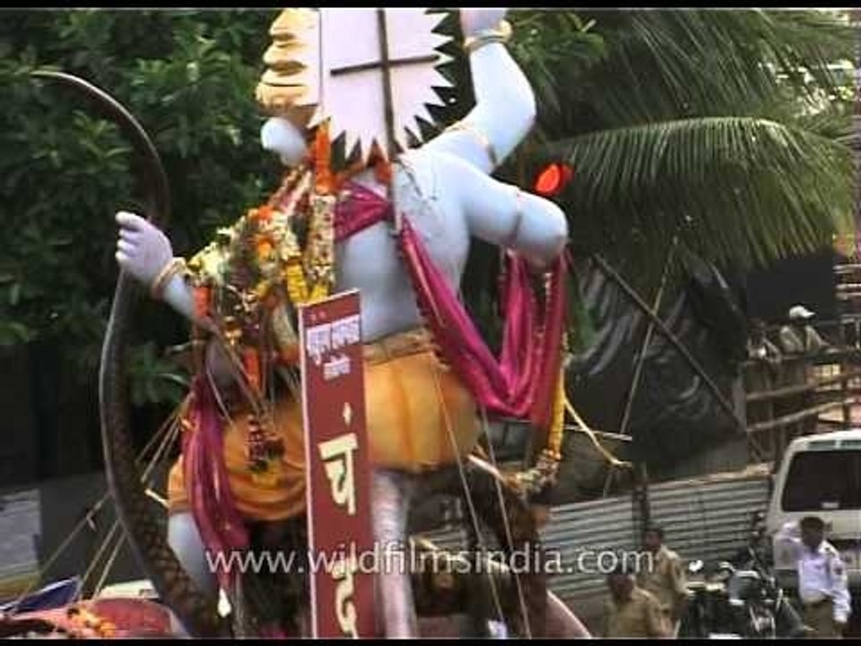 Ganesha devotees walk through busy traffic with the Ganesha Idol