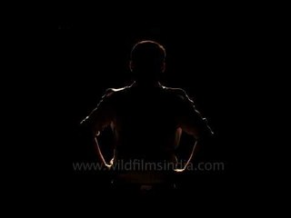 Silhouette in profile, against darkness