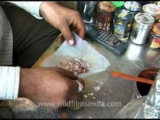 Paan seller makes paan masala in India