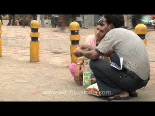 Indian lady dozing on a footpath, Delhi