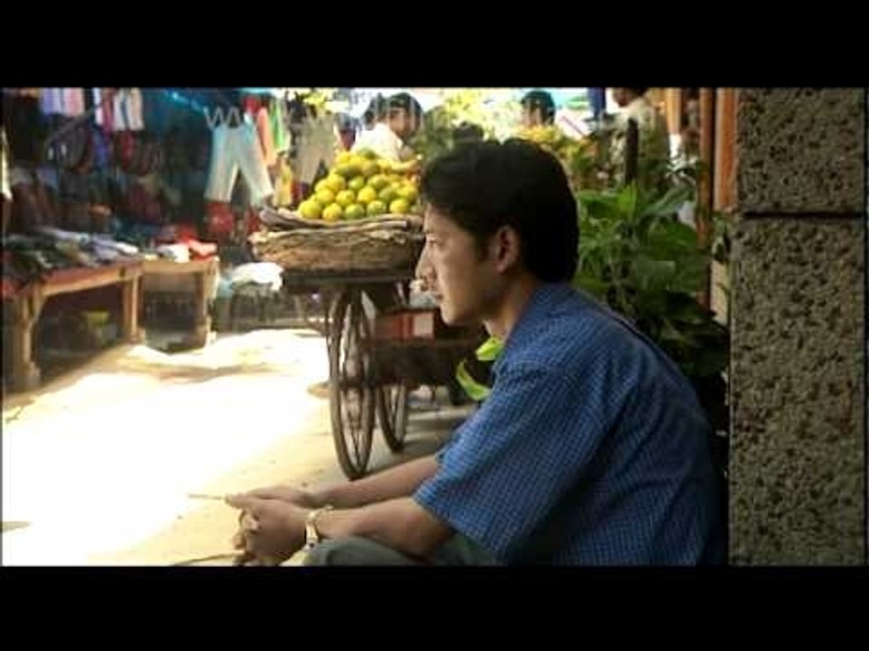 Tenzin smoking on a roadside pavement