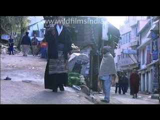 Old Tibetan woman walks though bazaar