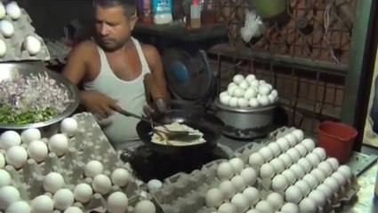 Man Making Egg Omelette and Serving  To HiS Customer -  Bread Omelette .