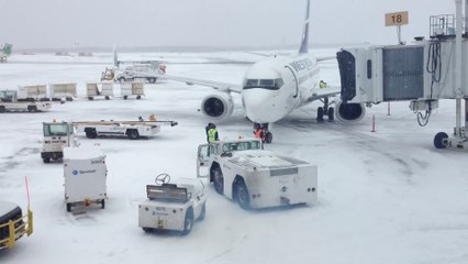Westjet airplane drifting away in windy cold day in the frozen Canada