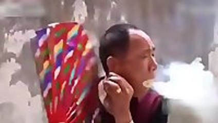 Chinese man blows smoke and fire from mouth