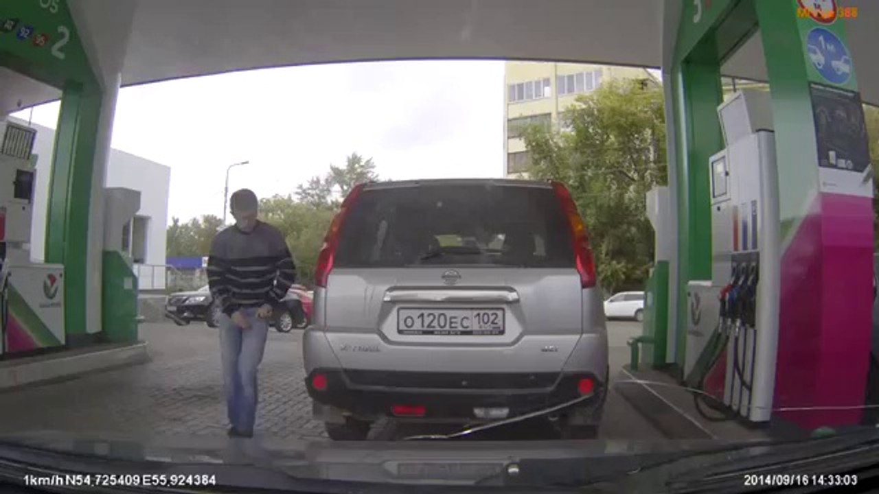 Une femme se trompe de voiture à une pompe à essence