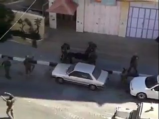 شاهد كيف يقوم الجنود بإدخال جثمان أحد الشهيدين القواسمي أو أبو عيشة داخل ناقلة الجنود بأقدامهم