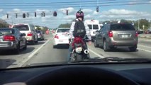 Un motard danse au feu rouge