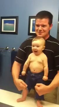 Un adorable bébé montre ses muscles avec son père