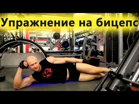 Юрий Спасокукоцкий показывает упражнение на бицепс. Сгибания рук на нижнем блоке кроссовера лежа.